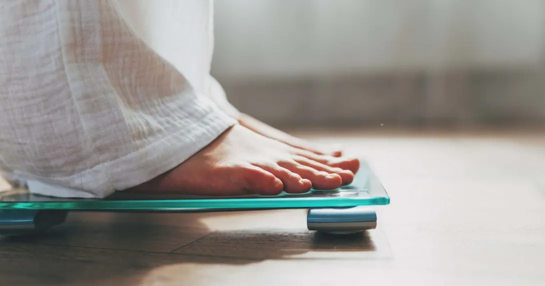 Person's feet standing on a scale