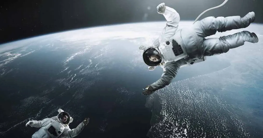 Two astronauts floating above earth in space reaching for each other
Two astronauts floating above earth in space reaching for each other