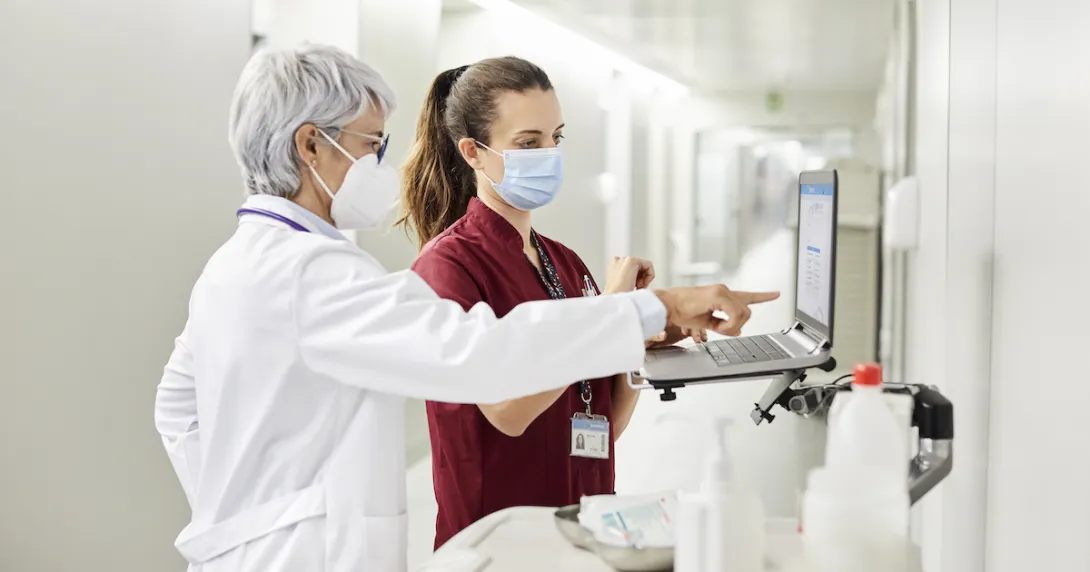 
  Healthcare professionals standing at a computer
