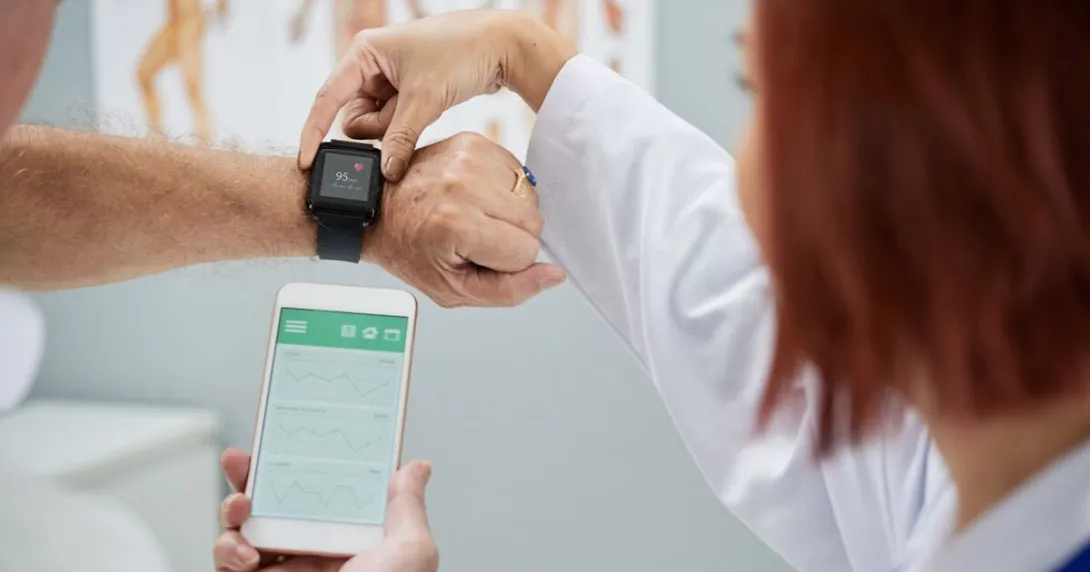 A doctor helping set up a patient's smartwatch.
A doctor helping set up a patient's smartwatch.
