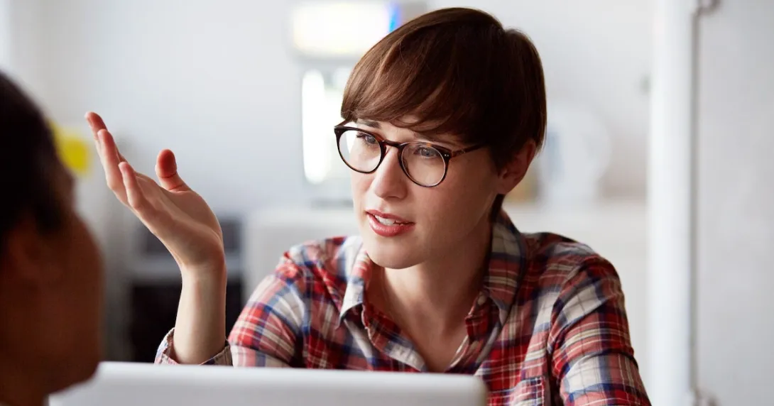Person on a laptop speaking with someone and wearing glasses