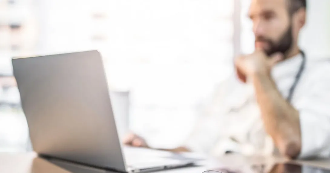 
  Person sitting at a desk looking at a laptop
