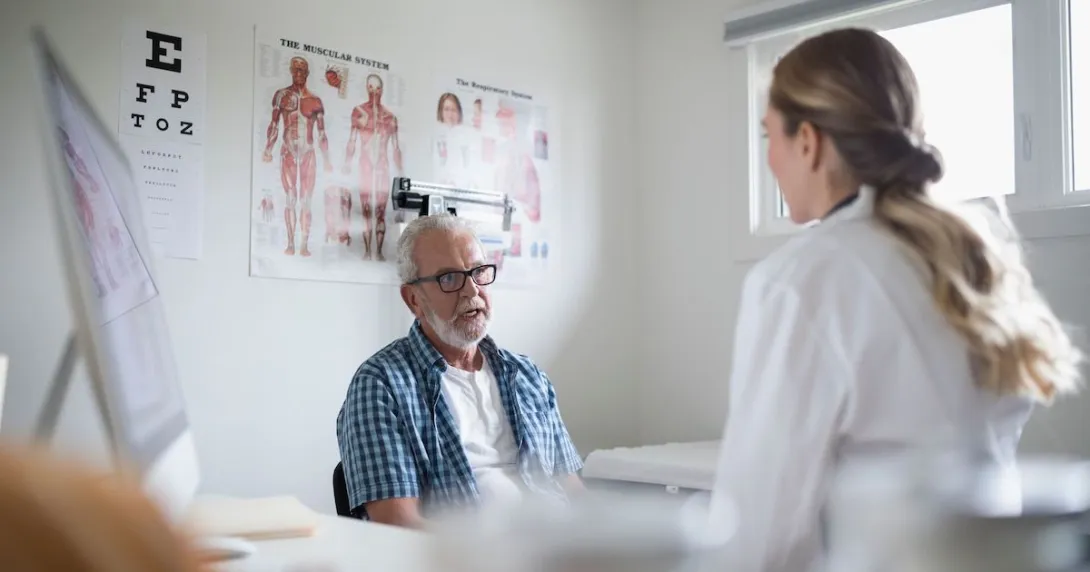 A senior patient in an in-person consultation with a doctor in a clinic A senior patient in an in-person consultation with a doctor in a clinic