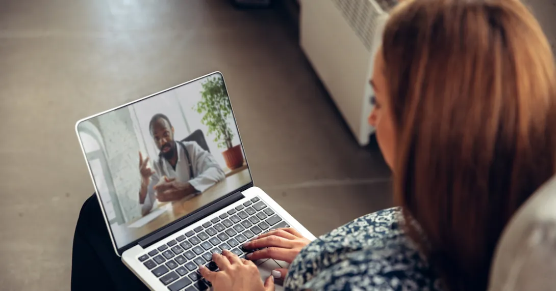 Person on a laptop speaking with a healthcare professional