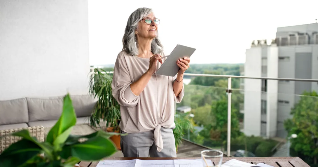 Person on a balcony looking at a tablet