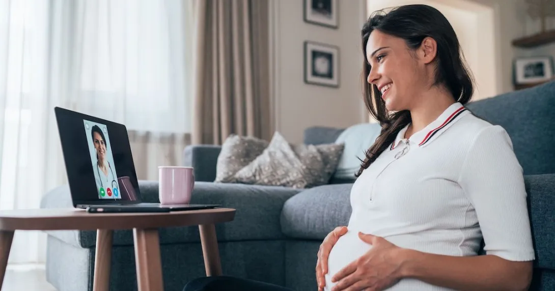 A pregnant person talks to a provider via telehealth A pregnant person talks to a provider via telehealth