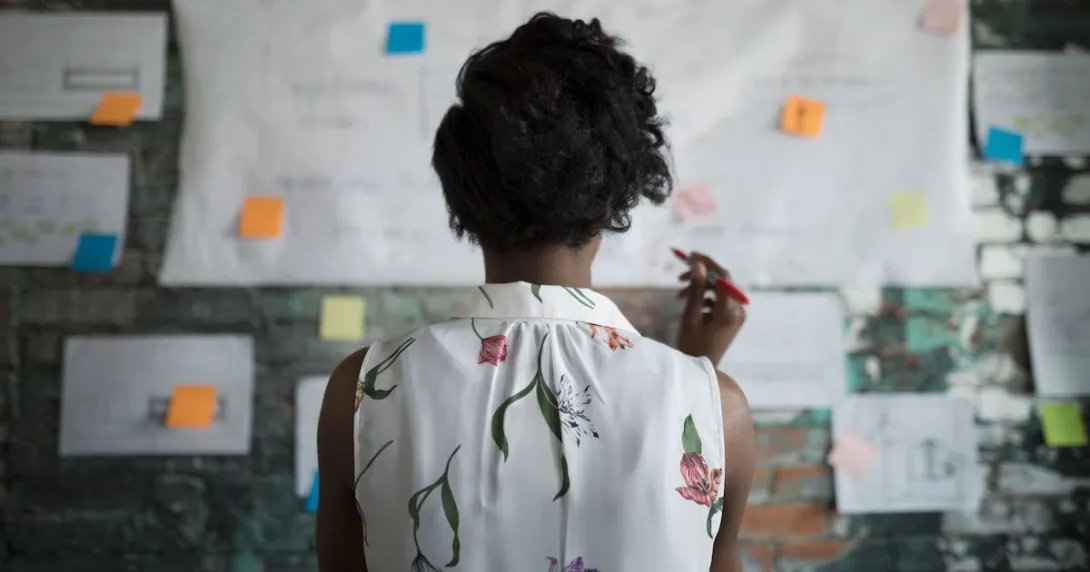 Person looks at plans posted on office wall Person looks at plans posted on office wall